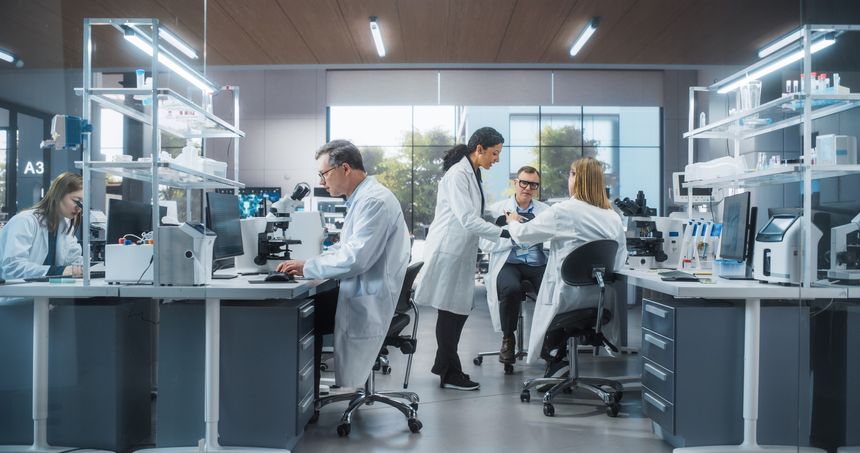 Three Scientists Discussing Latest Bioengineering Discoveries and Sharing Research Data on Vaccine Efficacy. Diverse Male and Female Colleagues Working in a Modern Medical Research Center
