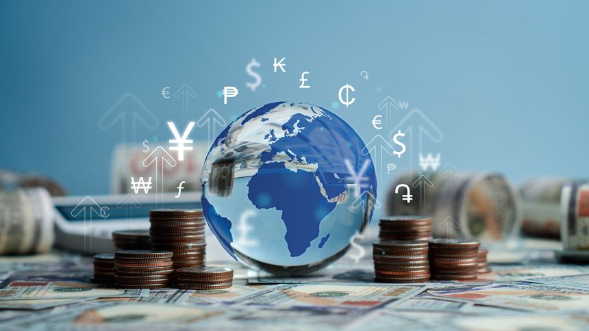 Crystal globe with symbols of international currencies including dollar, yen, yuan, euro, pound sterling, ruble and rupee placed on banknotes and stack of coins. World Bank ,Economic Inflation