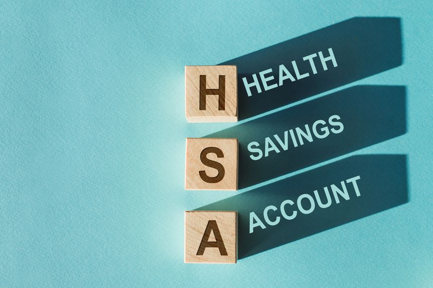 Wooden cubes with words HSA Health Savings Account with shadows. Beautiful blue background. Business and HSA concept.