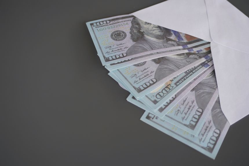 Top view image of money inside white envelope. Financial, bribery and reward concept.