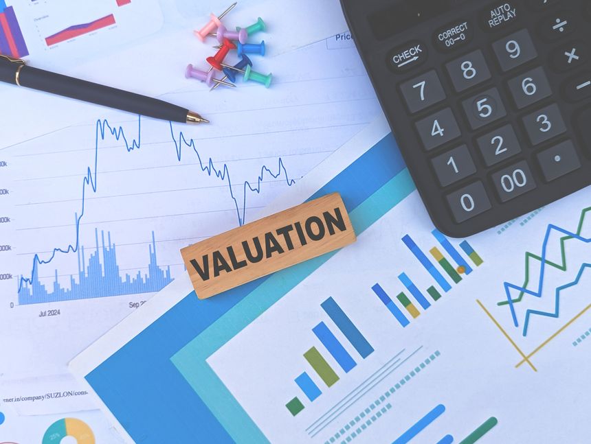workspace with valuation block, charts, calculator, and documents symbolizing financial analysis and business strategy