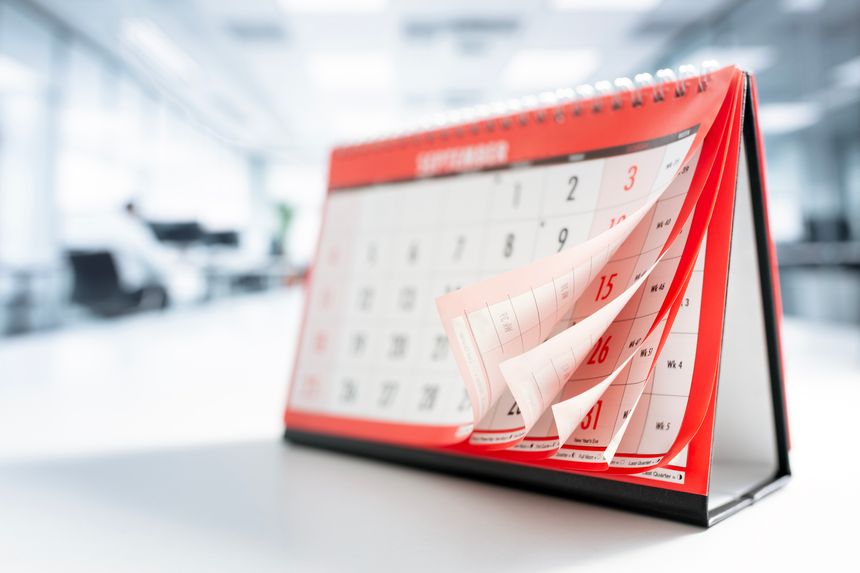 Calendar page turning showing months and dates in office background
