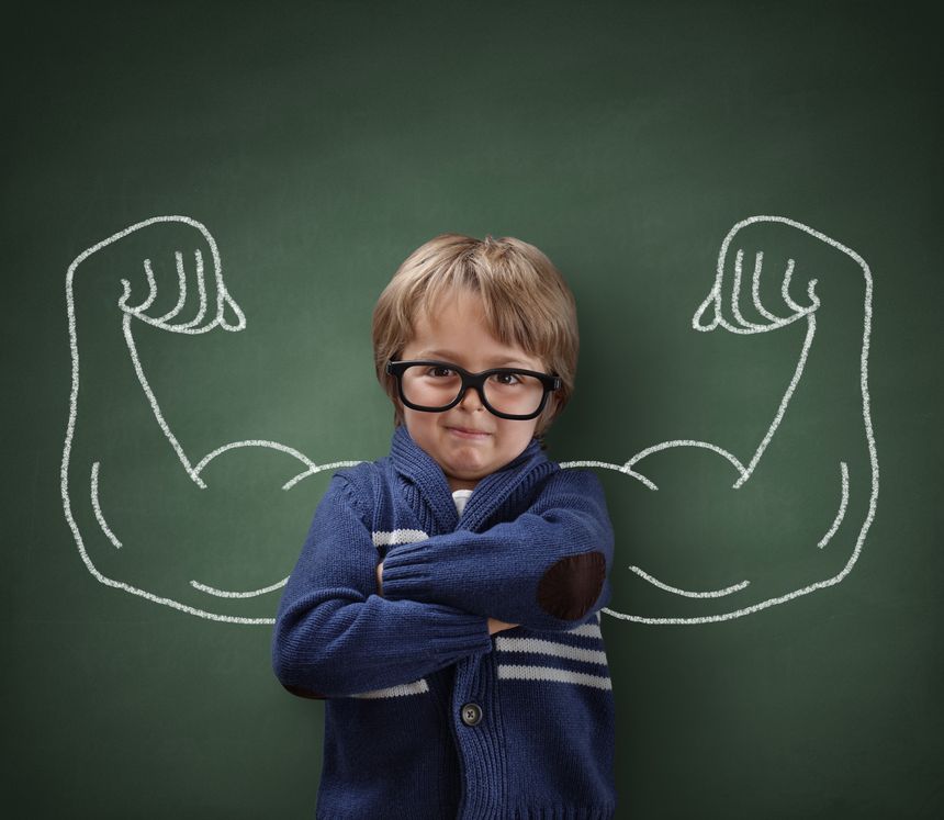 Strong man child showing bicep muscles concept for strength, confidence or defence from bullying