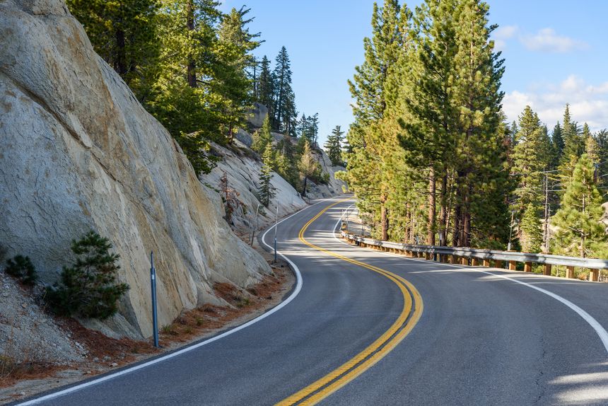 Empty winding road in the mountains on a clear autumn day. Lake Tahoe, CA, USA.