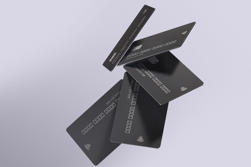 Floating black credit cards with contactless payment symbols on a light background, showcasing modern financial technology.