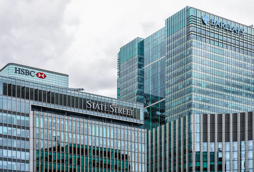 London, England, UK - 04 June 2025: An exterior view of the State Street, Barclays International (One Churchill Place Building), HSBC headquarters high-rise building (8 Canada Square Tower) in Canary Wharf, East London, UK. The modern glass and steel tower features the company’s signage displayed on its facade.