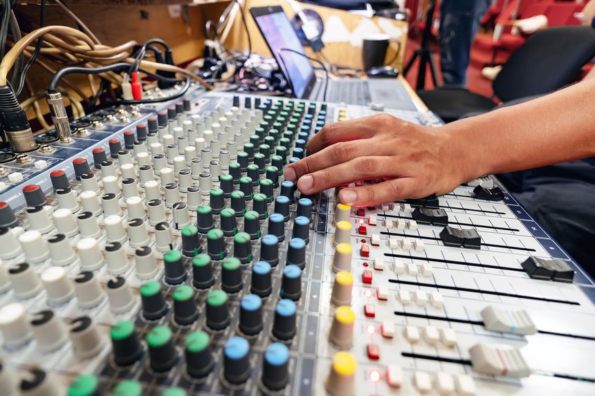 The male hand adjusts the scale to the Digital sound workstation next to the router and desktop