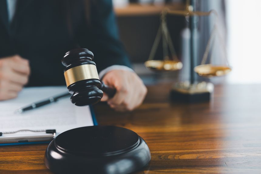 Justice and lawfirm concept. Female lawyer in office with brass scale. Woman hand gavel to bang. Law and justice trial session. Business lawyer notary stamping agreement, company secretary, validity.