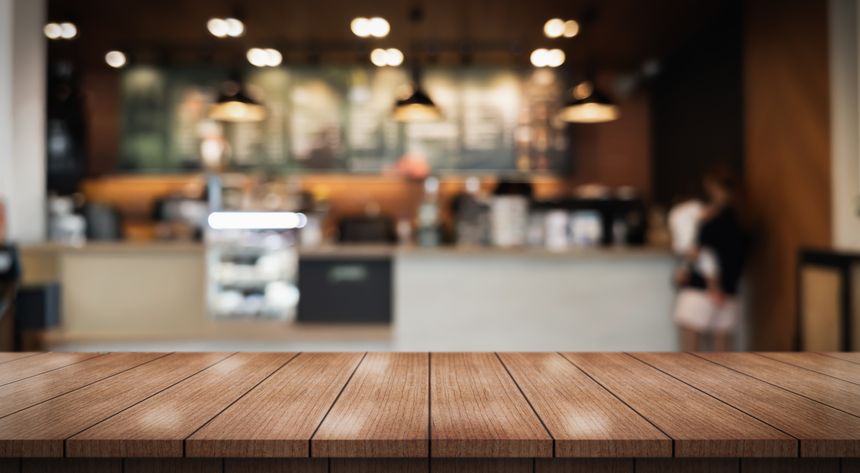 Empty wooden table top with lights bokeh on blur restaurant background.