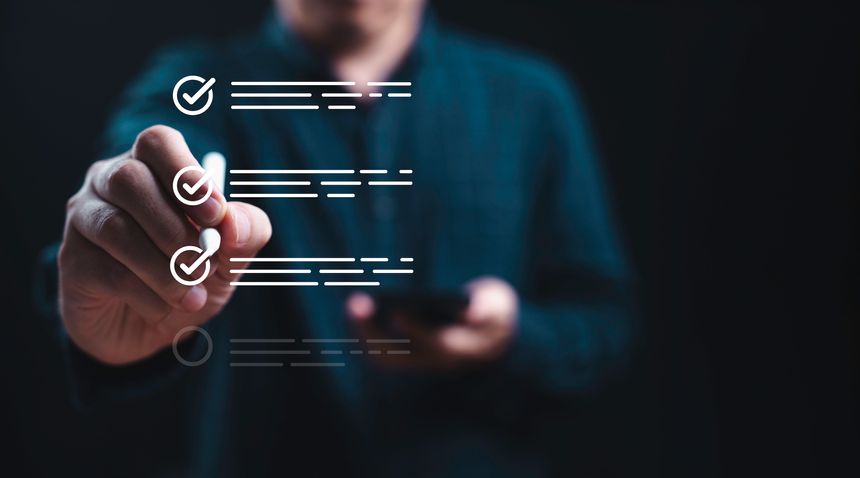 Businessman using electronic pend tick correct tick sign mark to checklist for quality assurance and certification concept.