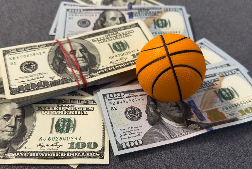 Small basketball on stack of dollars. High quality photo