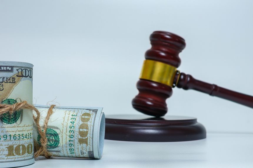 Judge gavel and bundled cash on white background representing financial crime, corruption, and legal consequences