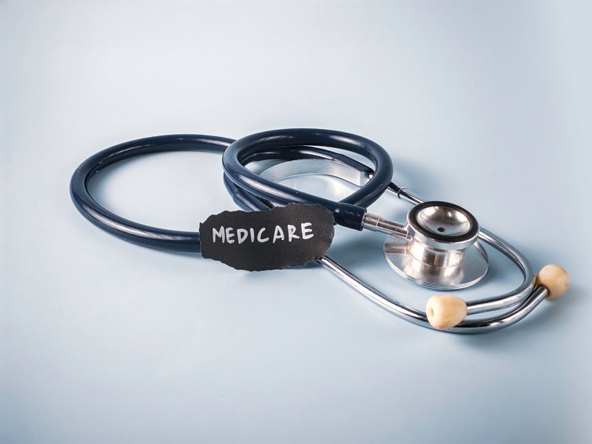 Stethoscope Near Piece of Paper with Medicare Text on Blue Background: A Concept for US Government Health Insurance and Senior Healthcare