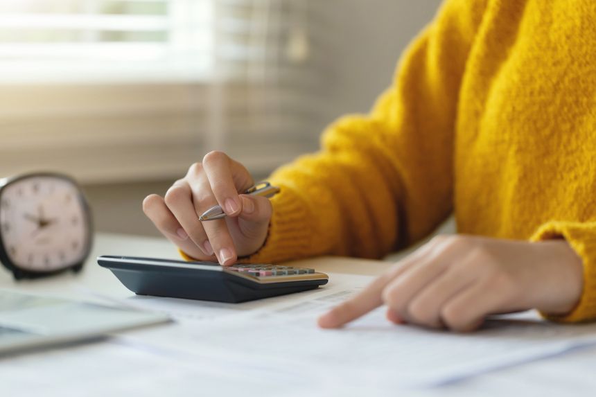 Tax deduction planning concept. Women use a calculator to calculate expenses and taxes to receive tax deductions for personal individual Income. tax return for individual persons.monthly expenses.