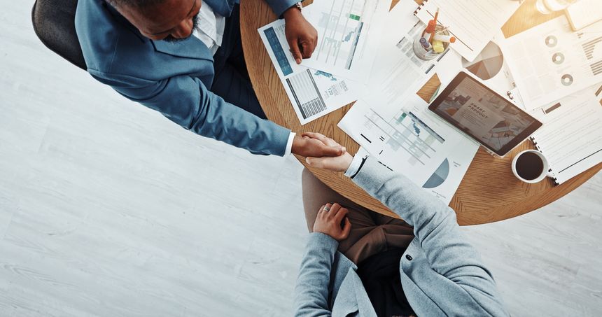 Meeting, handshake and people with paperwork, deal and gesture for client in boardroom or agreement. Colleagues, collaboration or shaking hands for opportunity in office, above and success of merger