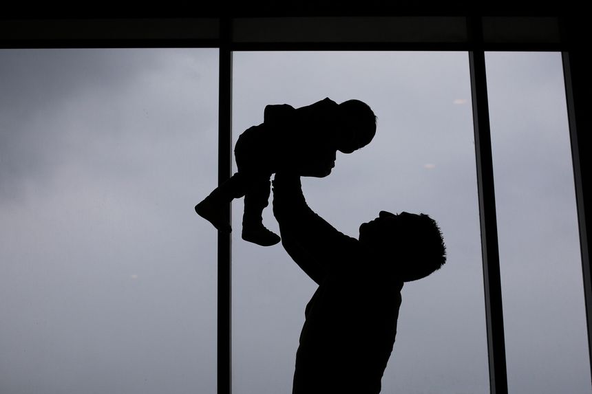 Silhouette of a father and baby girl at home on a cloudy day