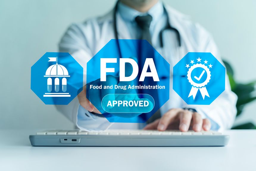 Physician using laptop with FDA approved interface icons, symbolizing regulatory compliance, drug safety, and medical device certification for healthcare and pharmaceutical industry.