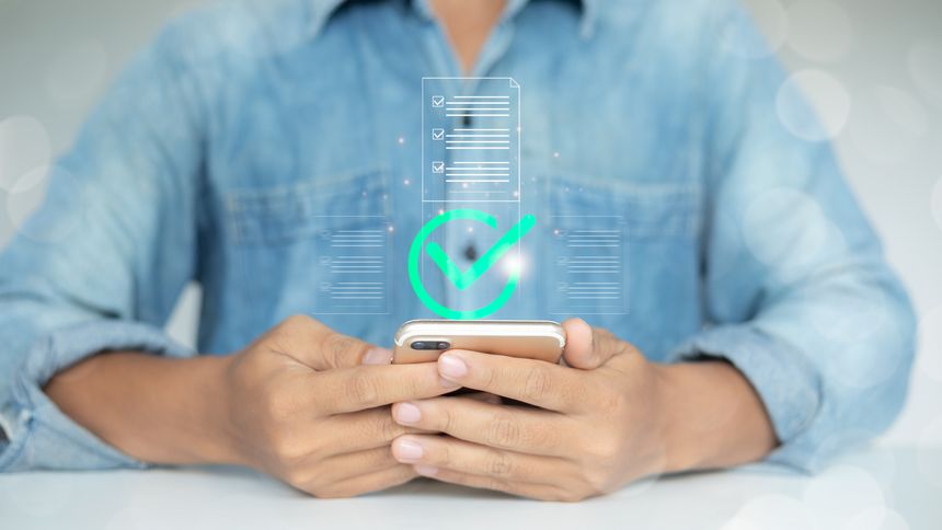 Man using smartphone with digital checklist and approval checkmark icon, representing mobile document verification, task completion,
