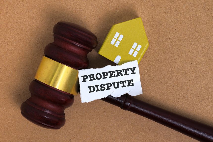 Property dispute concept with gavel and miniature house symbolizing real estate conflict and legal issues.
