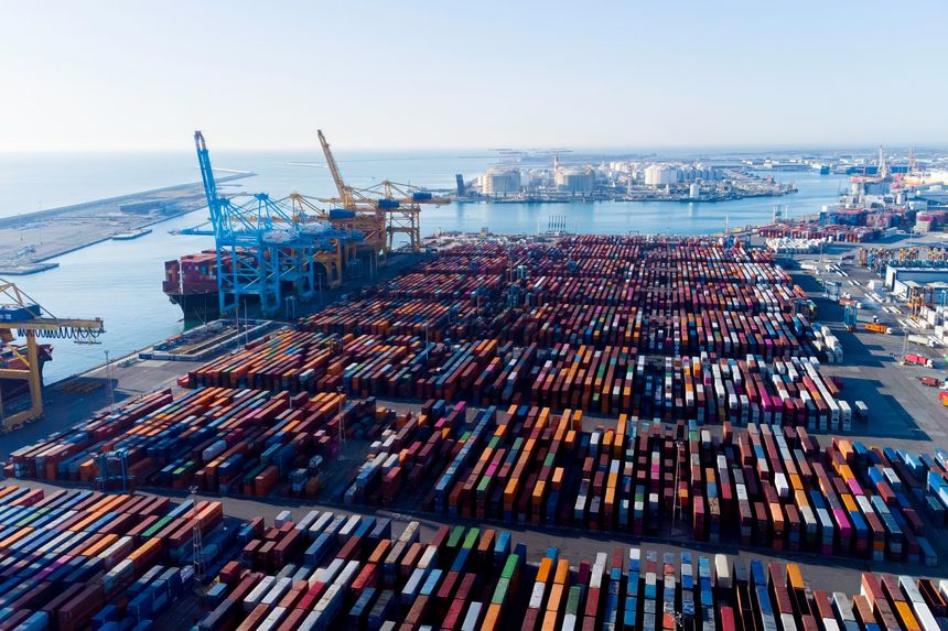 Aerial view of shipping containers and cargo ships in the sea port of Barcelona in Spain, Europe. Concept of sea and maritime trade and trade war due to tariffs. Commercial hub