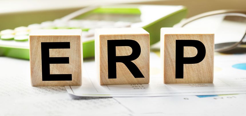 ERP inscription on the texture of wooden cubes. Wooden cubes on the background of the calculator and business documents. An inscription on a financial, business or economic theme.