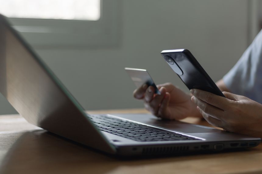 Female hand holding credit card and smartphone. Woman pay online, using banking service, entering information, shopping, ordering in internet store, making secure payment. fraud, phishing, scam phone.