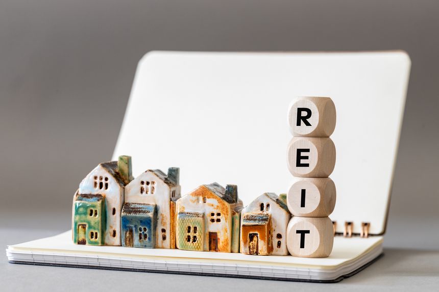 REIT symbol. Real Estate Investment Trust, Real Estate Investment Trusts with miniature houses Investment concept. copy space