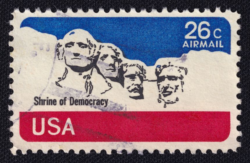 Old cancelled postage stamp printed in USA circa 1974 shows presidents of America George Washington, Thomas Jefferson, Theodore Roosevelt and Abraham Lincoln. Mount Rushmore National Memorial.