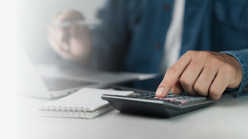 The concept of tax return preparation and financial management. Businessman calculates taxes using calculator and laptop. finance, Income tax,  tax documents, and savings