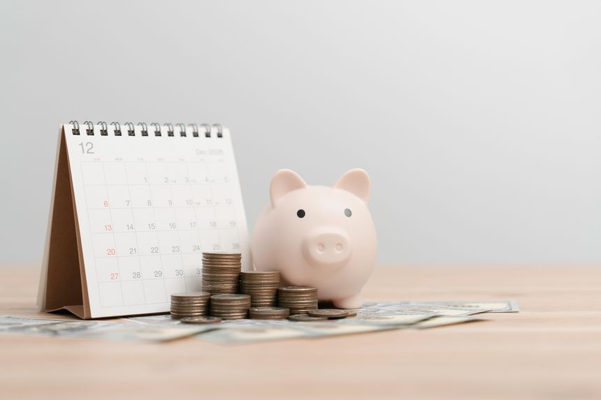 financial planning, savings money, and finance goals Concept. Piggy bank with stacked coins and a monthly calendar and personal finance tracking for investment goal, and personal budget management