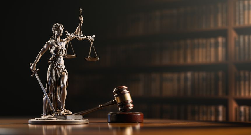 Legal Concept: Themis is the goddess of justice and the judge's gavel hammer as a symbol of law and order on the background of books.