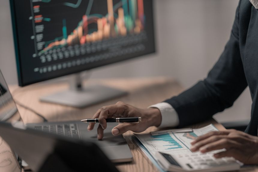 Businessman analyzes growth charts on laptop for financial insights in using tablet and laptop to analyze financial charts. stock market growth Investment strategy