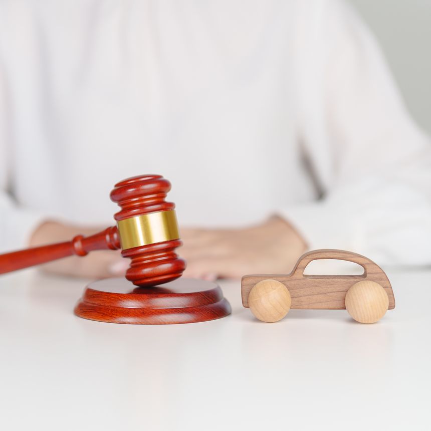 Car Law, Insurance, auto Tax, Auction and Bidding concepts. Wood small toy car models with Judges gavel on desk in courthouse.
