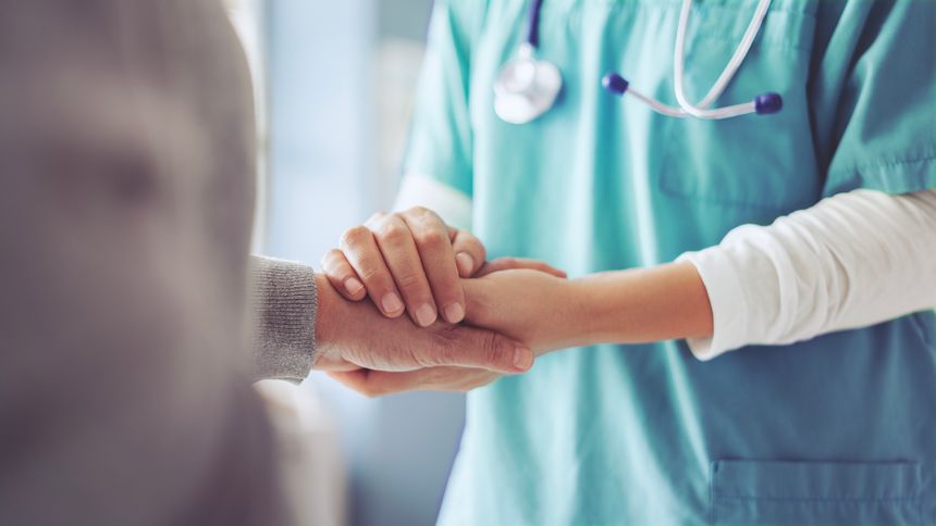 Hands holding old woman's hands