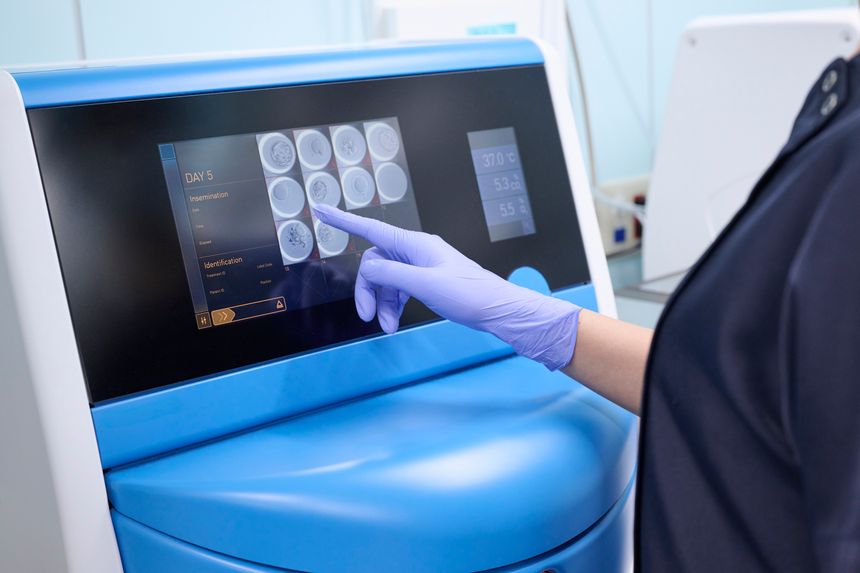 Embryo culture specialist observing fertilized eggs in an incubator