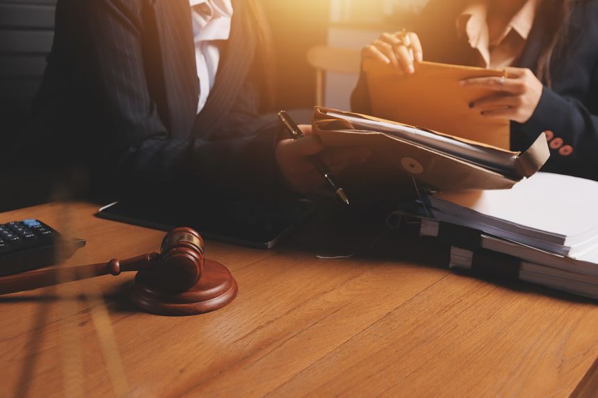 Attractive young lawyer in office Business woman and lawyers discussing contract papers with brass scale on wooden desk in office. Law, legal services, advice, Justice and real estate concept.