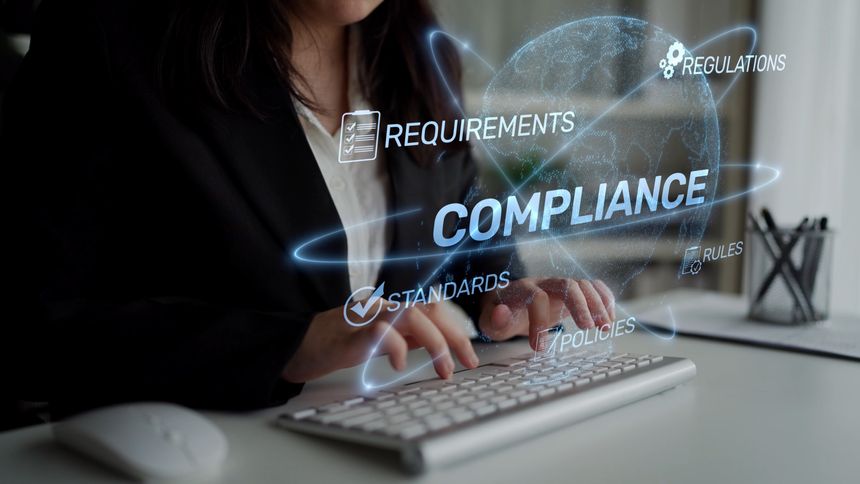 A business professional focuses on compliance tasks, displaying a digital interface of regulations and standards, signifying the importance of adherence in a modern office.