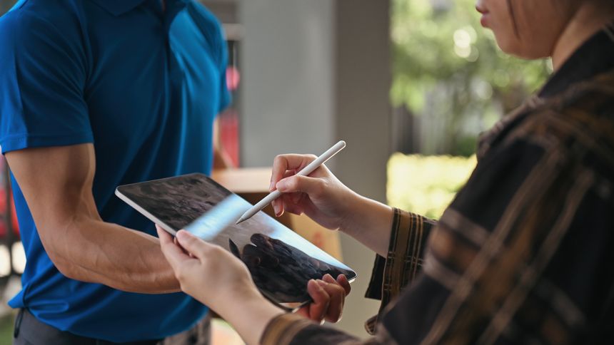 Close-up of a customer using a stylus to sign a delivery confirmation on a tablet, E-signature process for package acceptance at the doorstep.