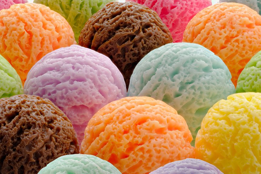Assortment of multi-colored ice cream scoops in various flavors. Close-up shot, vibrant colors and creamy textures, abstract background for food advertising, dessert menus and summer-themed promotions.