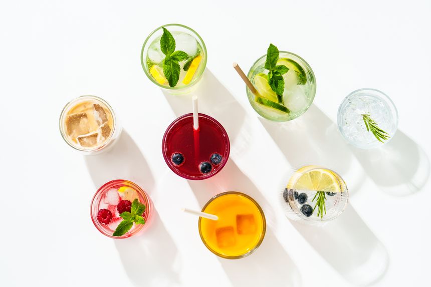 Summer drinks, colored cocktails on white background. Lemonade, mojito, raspberry lemonade, tonic water and iced coffee.