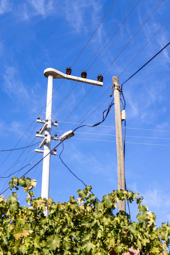 Old cupped electricity poles in a village setting
