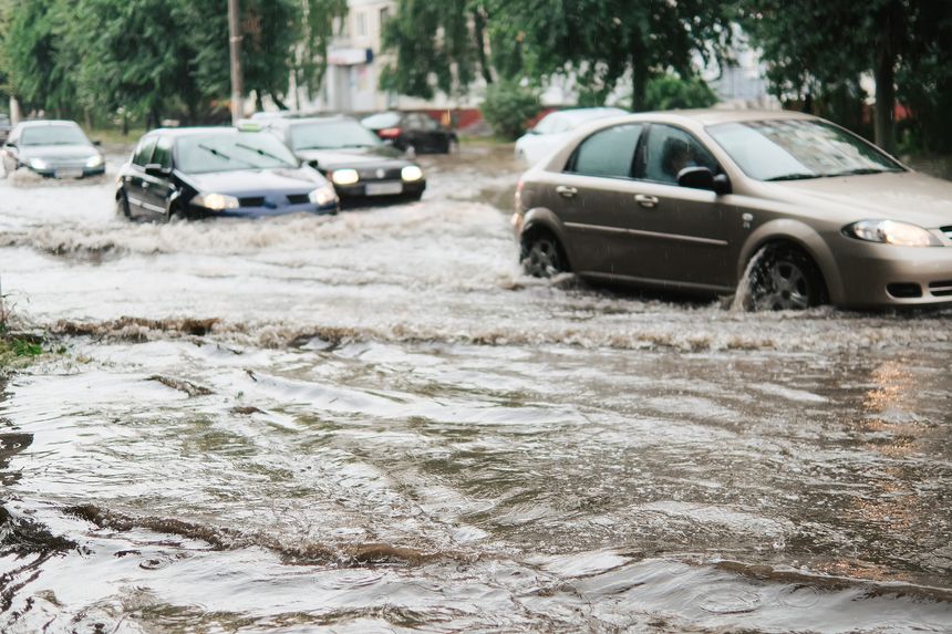 Cars on the street flooded with rain.