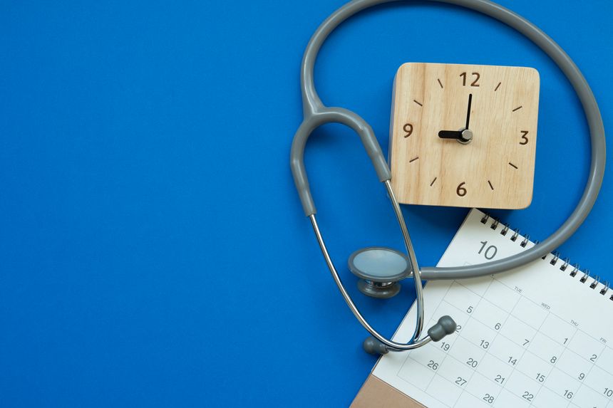 Top view of stethoscope, clock  and calendar on the blue background, schedule to check up healthy concept