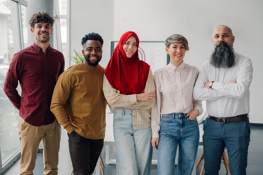 Five business colleagues smiling at the camera in the office