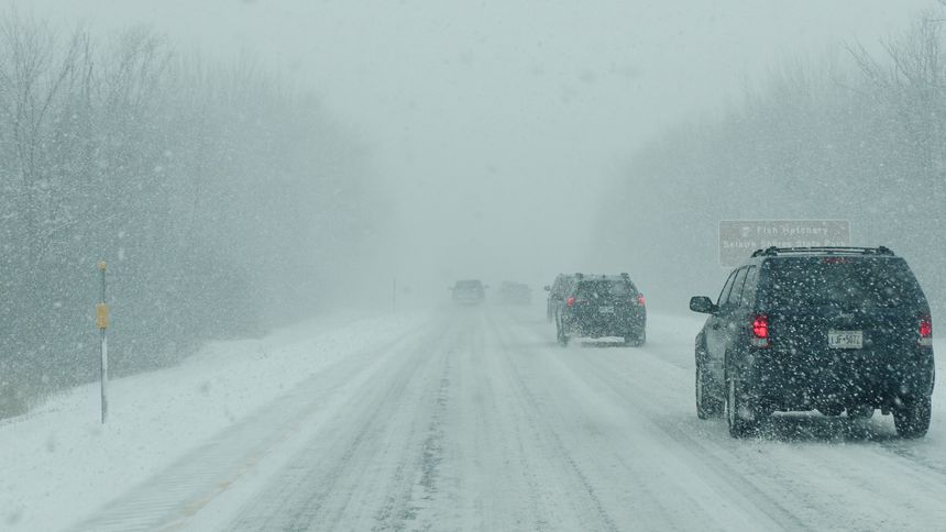 Syracuse NY, United States - January 3, 2025: Vehicles drive along a snowy road amidst heavy snowfall and winter weather conditions