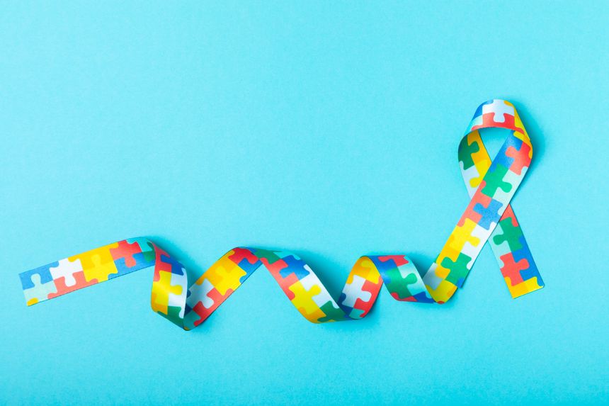 Autism ribbon. Autism awareness day. World autism awareness day with puzzle pattern ribbon on textured background. Colorful puzzle ribbon. Medicine concept. Space for text. Copy space