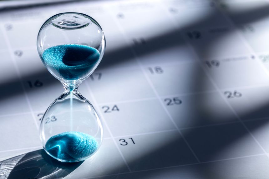 Hour glass on calendar background concept for time slipping away for important appointment date, schedule and deadline
