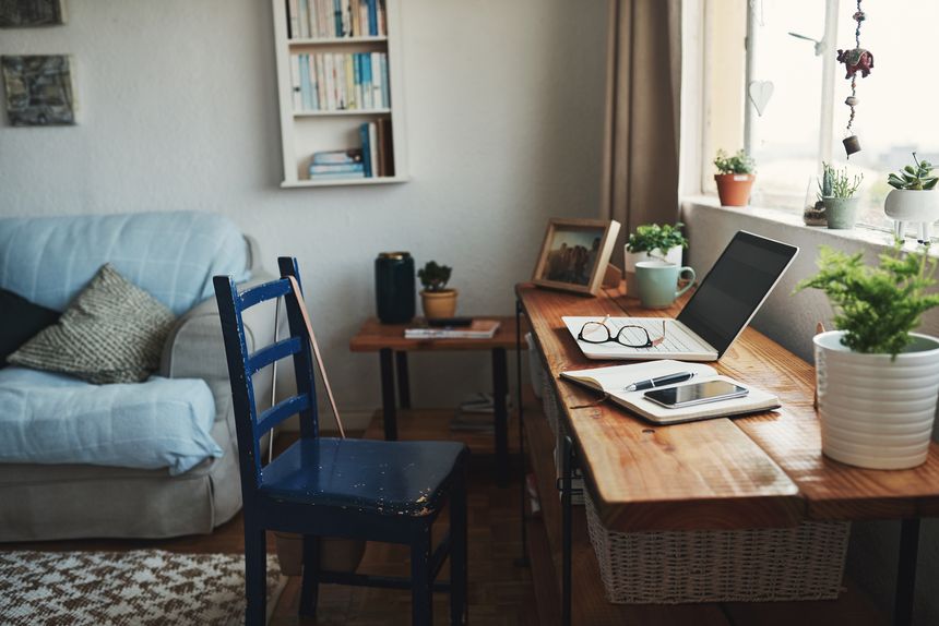 Cropped shot of technology and a notebook on a desk in an empty home office during the day