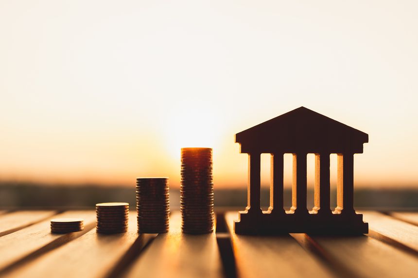 Bank symbol with with coins stack. Concepts of the banking system, rising interest rates, inflation, deflation, and savings.