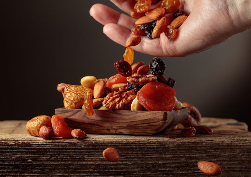 Dried fruits and nuts is poured in a wooden dish.